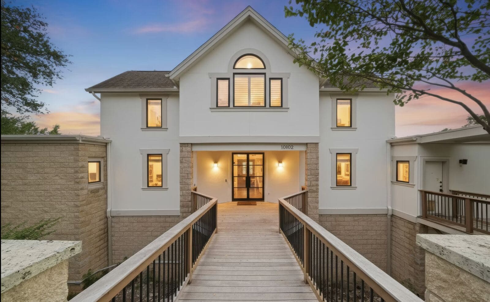 Home entrance with a bridge walkway at dusk