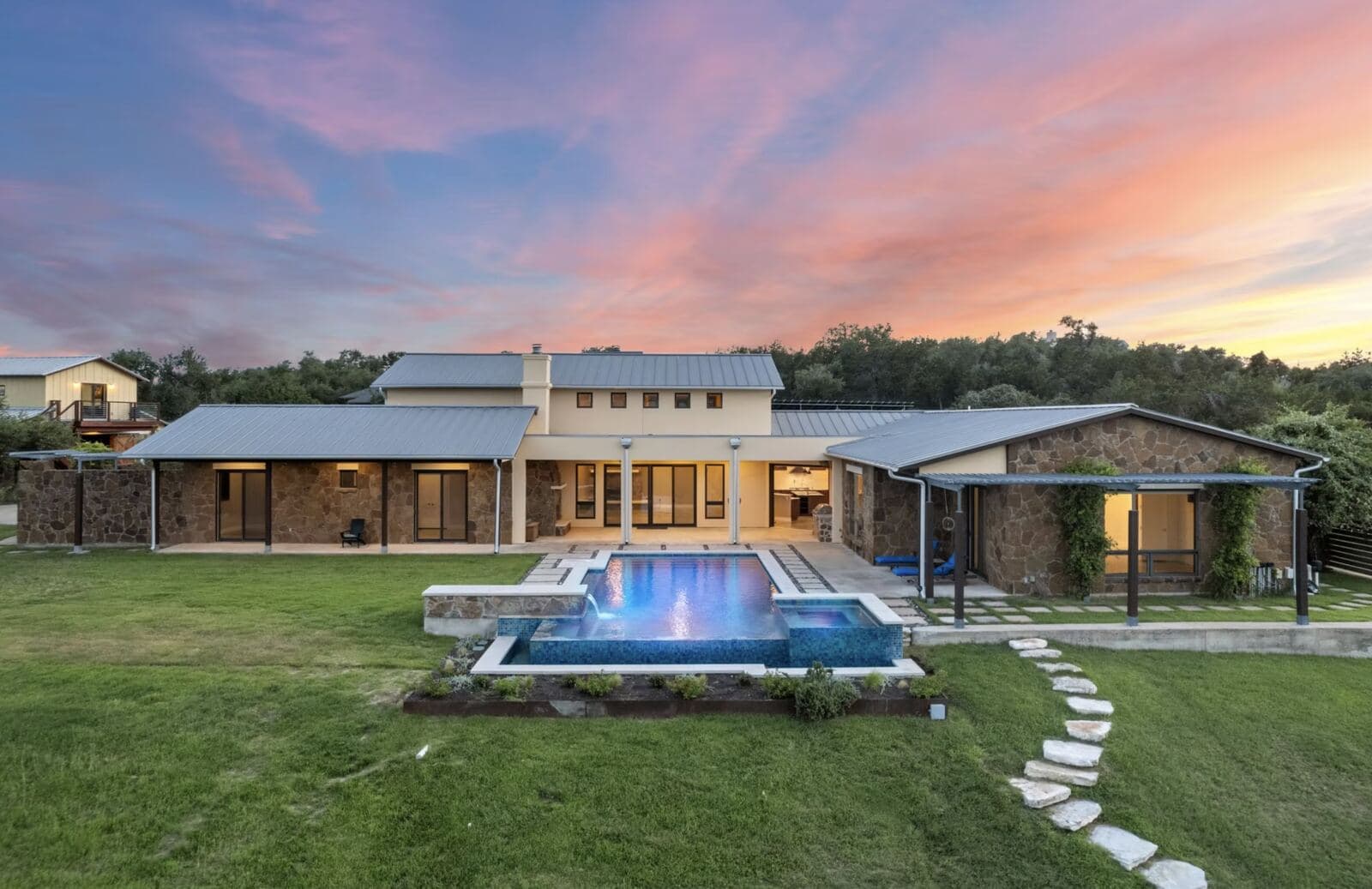 Hill Country home with a pool photographed at sunset
