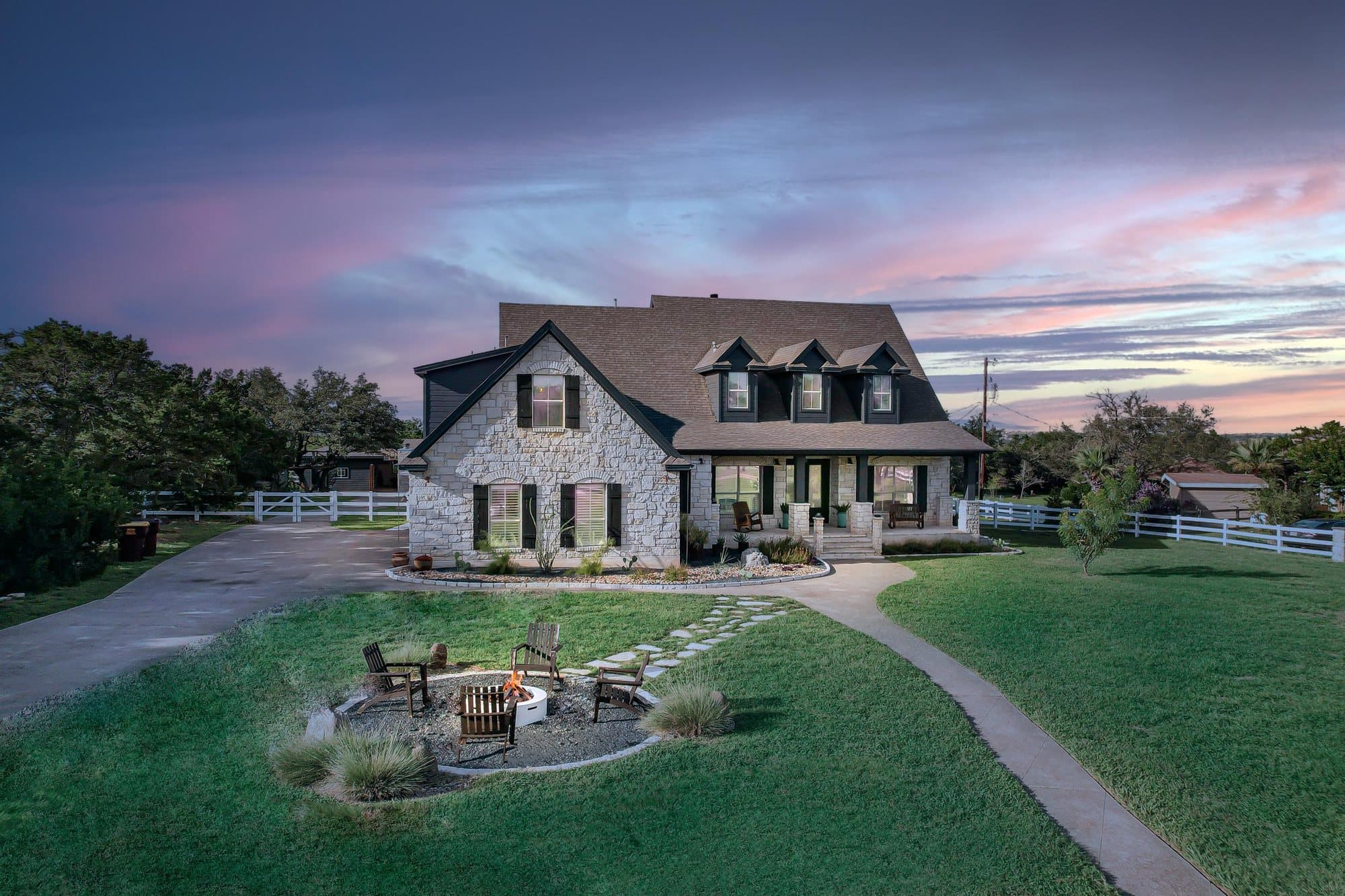 Stone farmhouse at twilight with a fire pit